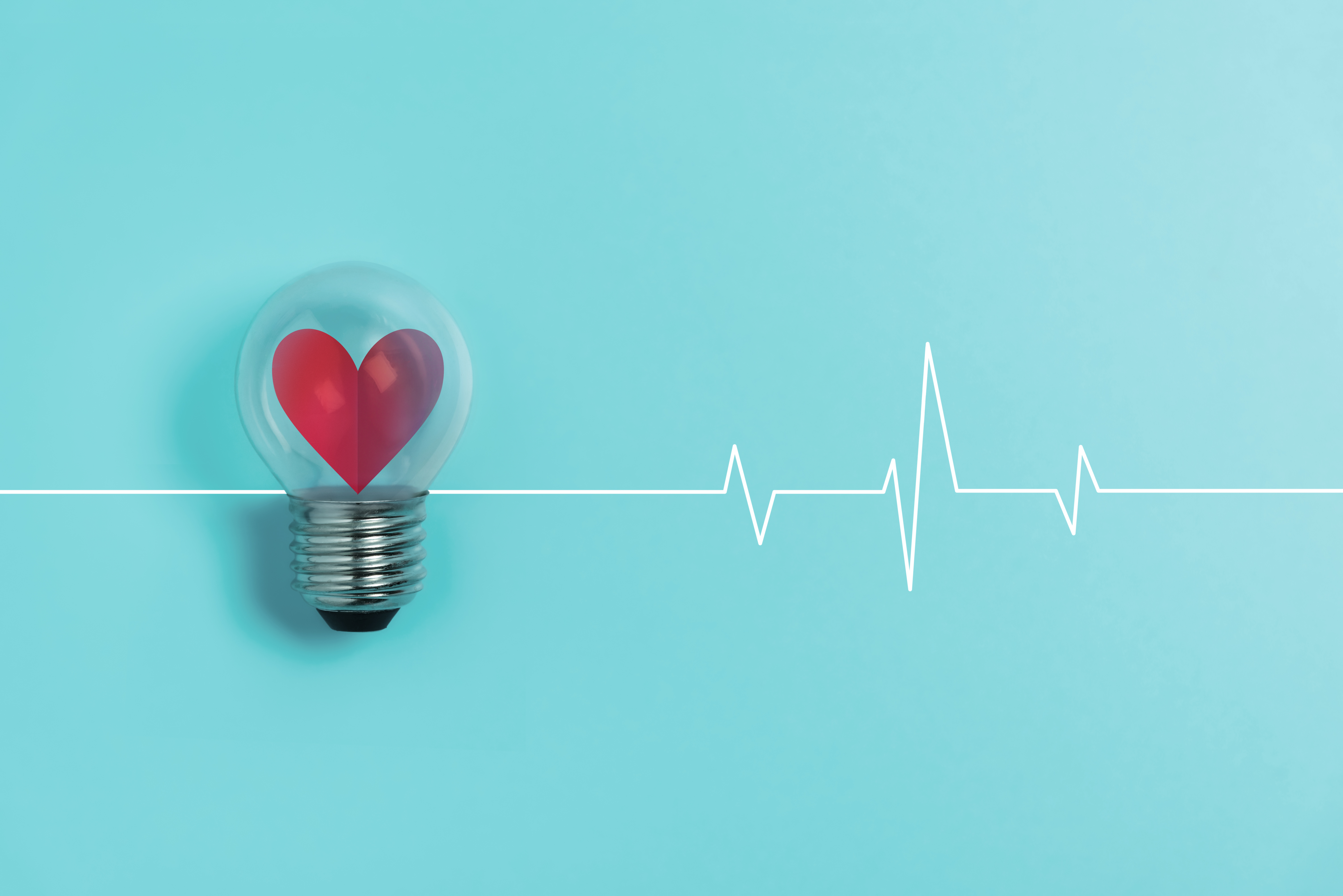 Red heart in light bulb with Heartbeat pulse on blue background.