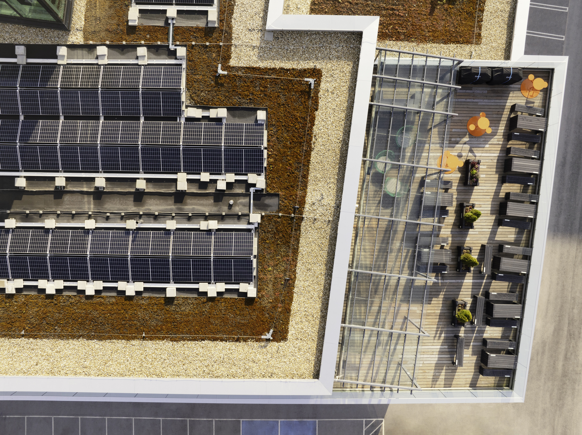 Rooftop solar panels and a deck on a modern office building, showcasing how residential customers and businesses are leveraging solar power and government incentives to contribute to a sustainable future and enable utilities to meet net zero goals.