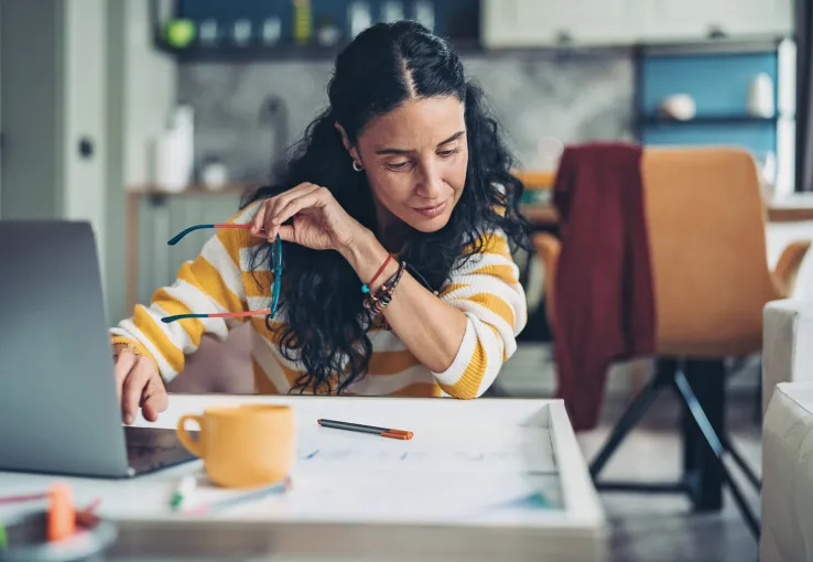 Woman in a yellow and white shirt reviewing market research data to uncover actionable insights