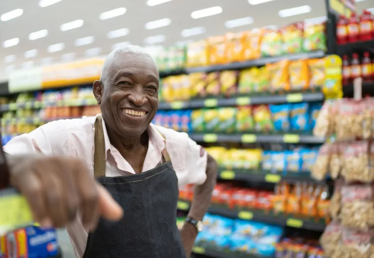 Smiling employee in grocery store aisle